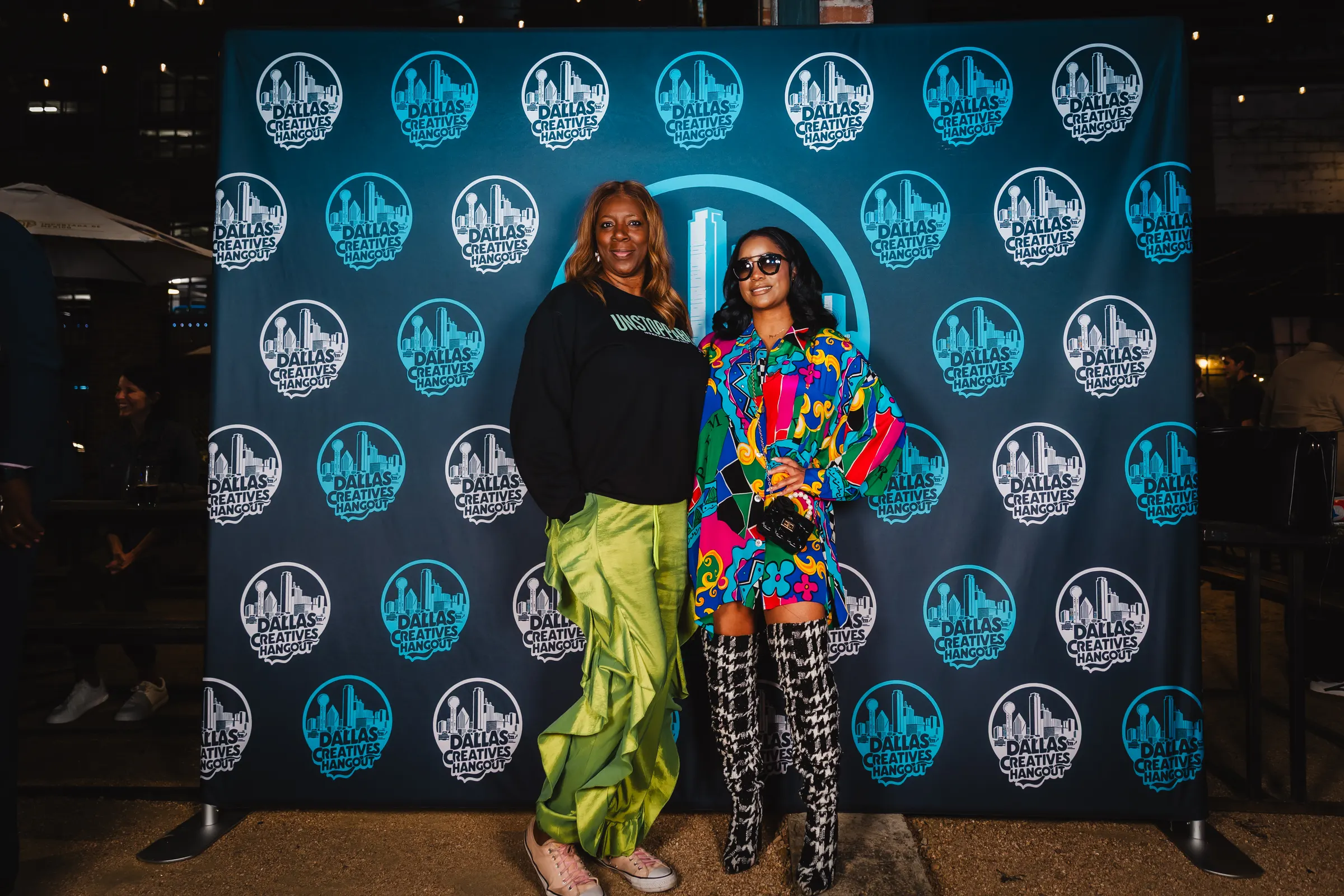 Two creatives in bold outfits at the Hangout backdrop